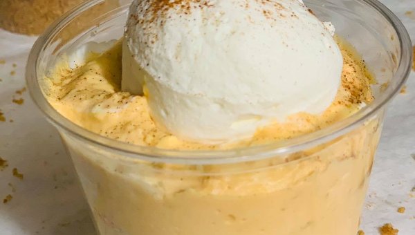 Keto mousse cup topped with whipped cream and a dusting of cinnamon