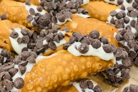 Cannoli filled with cream and dipped in chocolate chips
